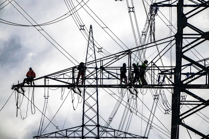 Work on a 380 kV high-voltage overhead line, new construction, along the A57 motorway, near Meerbusch, workers on the boom of the high-voltage pylon, North Rhine-Westphalia, Germany