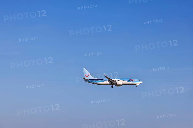 Passenger airplane from the travel company Tui with tourists to a resort flying on a blue sky, Mallorca, Spain