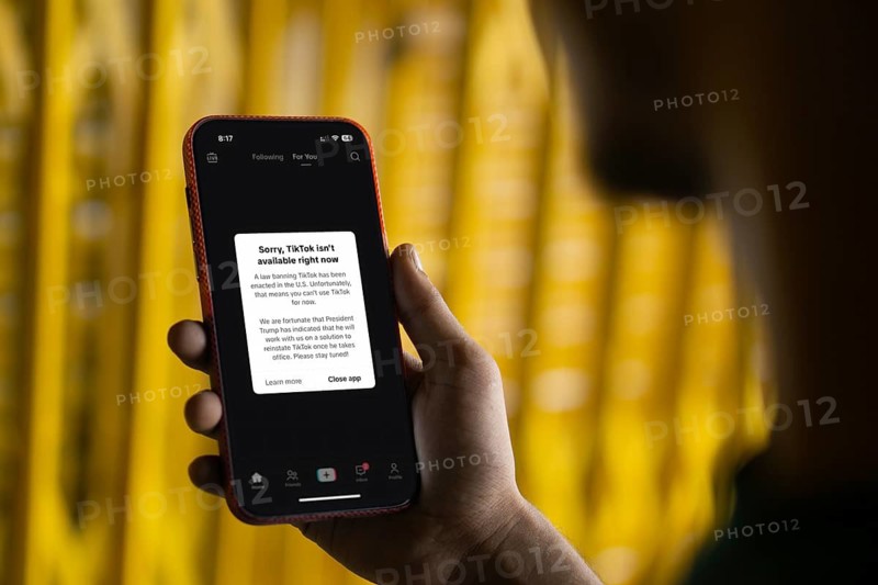 An iPhone screen with the TikTok homepage showing Sorry, TikTok isn't available right now