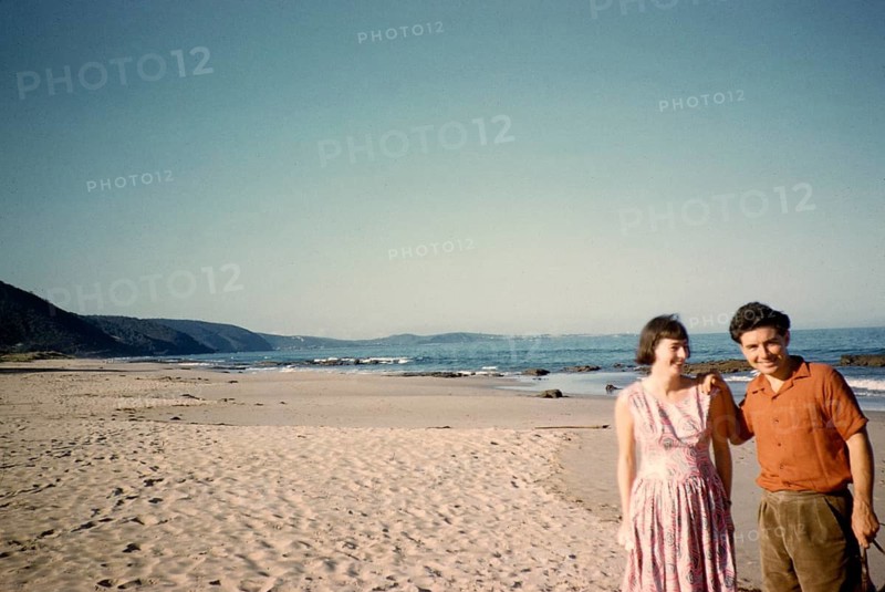 Man and woman standing on the sandy beach of Lorne, Victoria, Australia, 1956
