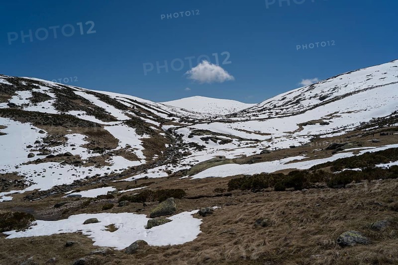 Serene snowy landscape of Sierra de Gredos showcasing the convergence of snow-covered ridges under a vivid blue sky, offering an ideal travel destination for nature enthusiasts