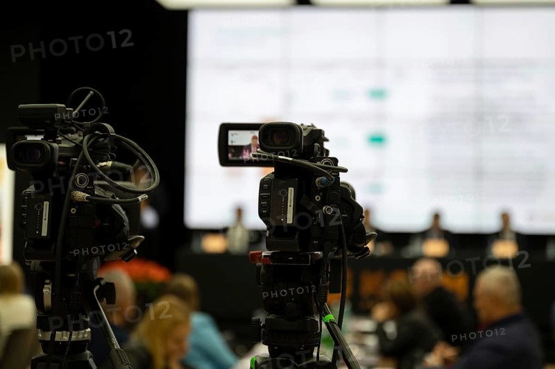 Camera during press conference with speaker in the background in Lubin, Poland