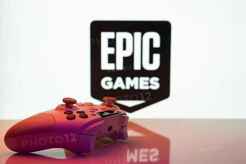 Game controller in front of Epic Games logo on a white background