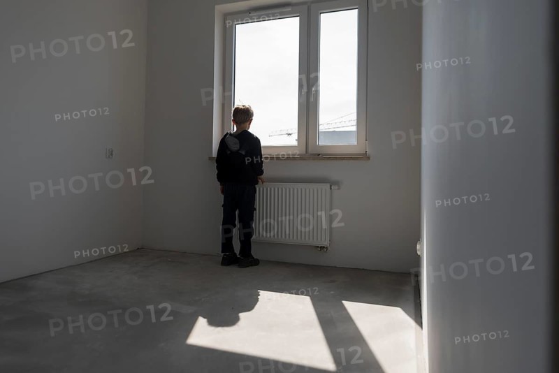 Happy young boy in his new empty room in the new flat in Wroclaw, Poland