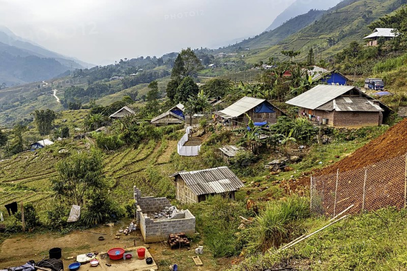 Small village with houses surrounded by fields and mountains, farms in the rice paddies near Sa Pa in Vietnam