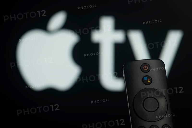 Dhaka, Bangladesh- 21 Jan 2026: Close-up of a smart TV remote control against a blurred Apple Tv logo