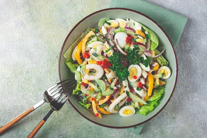 Salad with squid, fresh cucumber, eggs, sweet pepper, red onion, with dressing, homemade, no people