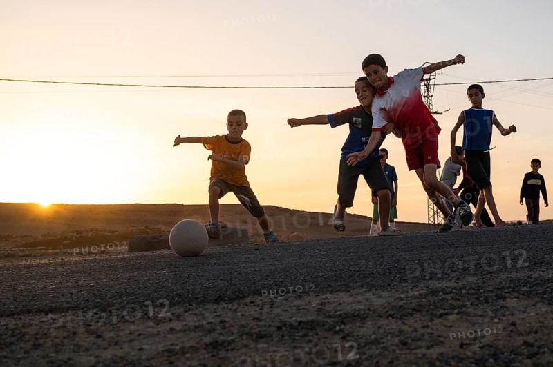 Taouloukoult, MOROCCO - OCTOBER 6, 2024: young boys spend the afternoon playing amateur football on a stone pitch