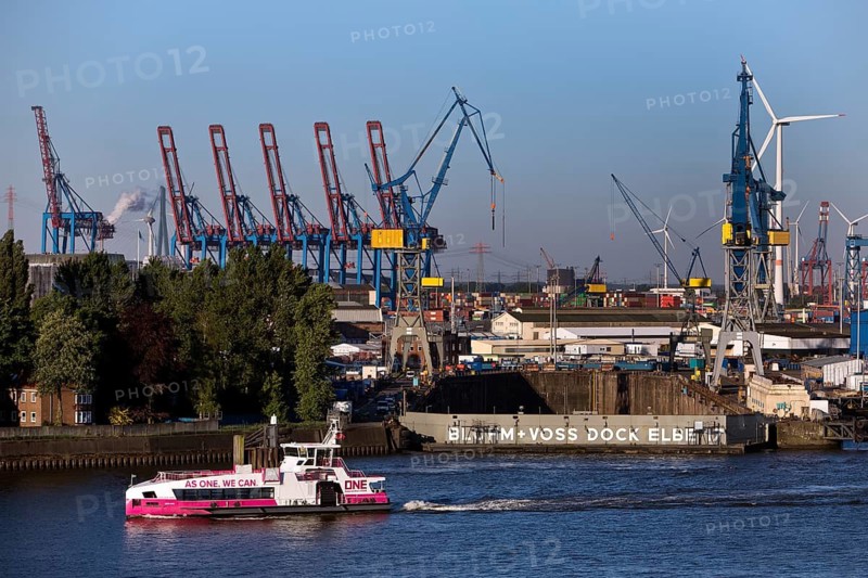 Hybrid harbour ferry Neuland of HADAG in front of the empty Blohm und Voss dry dock Elbe 17 in the port of Hamburg, Germany