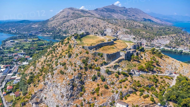 Aerial drone view of Rozafa Castle in the city Shkoder and its walls next to the lake and the river. Albania