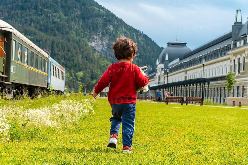 Boy on his back running in the old train station of Canfranc in the Pyrenees. Spain