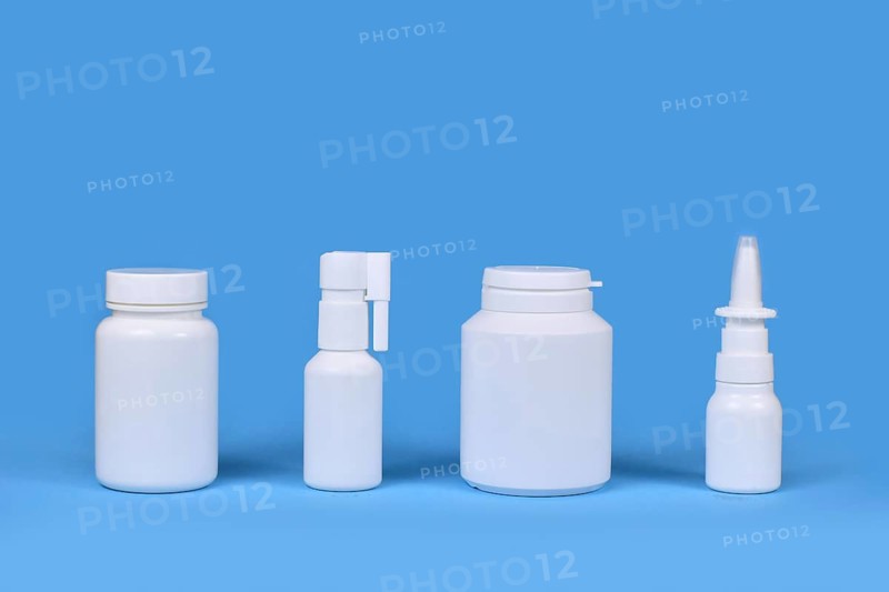 Medication for cold and flue. Nasal spray, throat spray, pills in a row on blue background