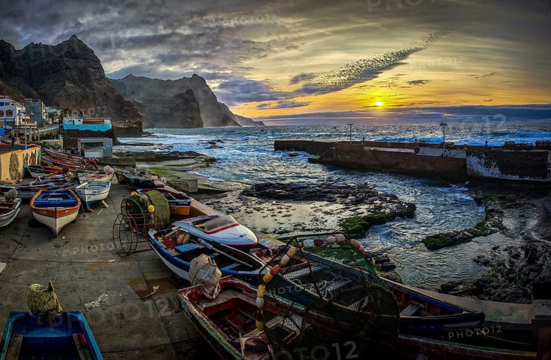 Sunset over a coastal landscape with colorful fishing boats and mountains, graffiti, romantic harbor scene in dramatic evening light, Ponta do Sol, Santo Antao, Cabo Verde, Cape Verde, Cape Verde