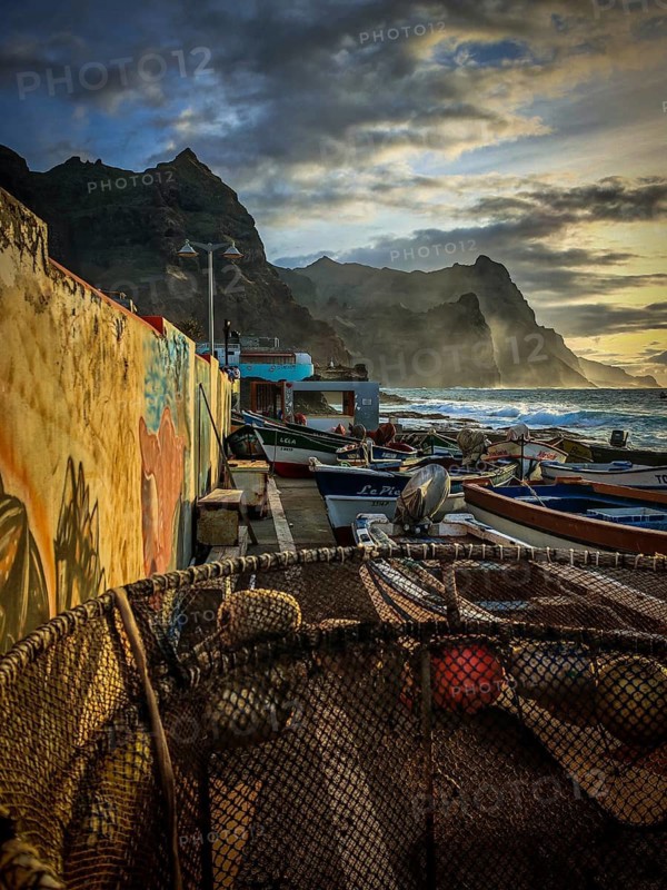 Harbour with fishing boats on painted wall, graffiti, mural, waves hitting the rocky coast in romantic evening light, sunset, harbor scene, Ponta do Sol, Santo Antao, Cabo Verde, Cape Verde, Cape Verde