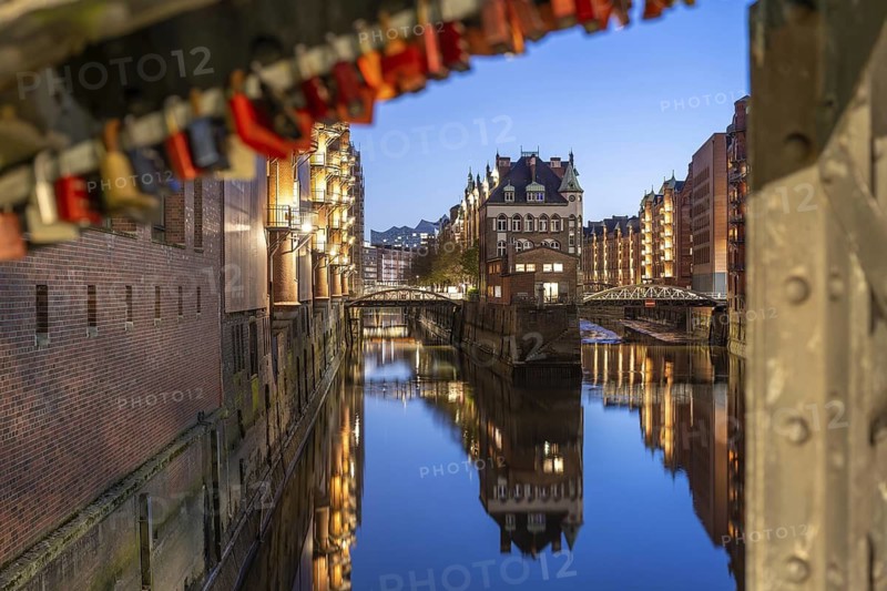 Water castle in Hamburg's Speicherstadt at blue hour with love locks in the foreground and reflection in the water, Hamburg, Germany