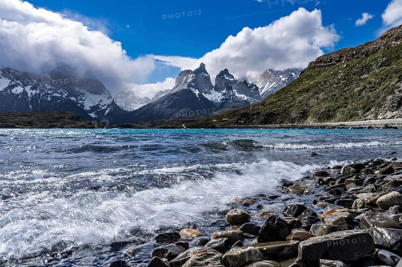 Cuernos del Paine, snow-capped peaks of the Paine massif behind turquoise Lake Nordenskjöld with rocky shore and swell, Torres del Paine National Park, Patagonia, Chile