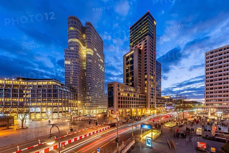 Zoofenster Berlin in the evening. Skyscrapers of the Hotel Waldorf Astoria and Upper West with the Hotel Motel One. In front of it, a road with cars and light trails. Berlin, Germany