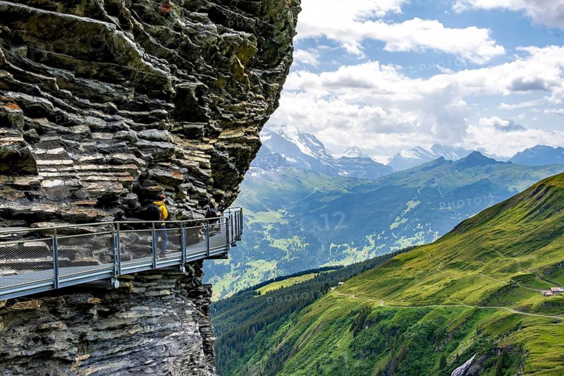 Young man on First Cliff Walk, metal trail on a rocky outcrop, Grindelwald First, in front of impressive mountain scenery, Bernese Alps, Bernese Oberland, Switzerland