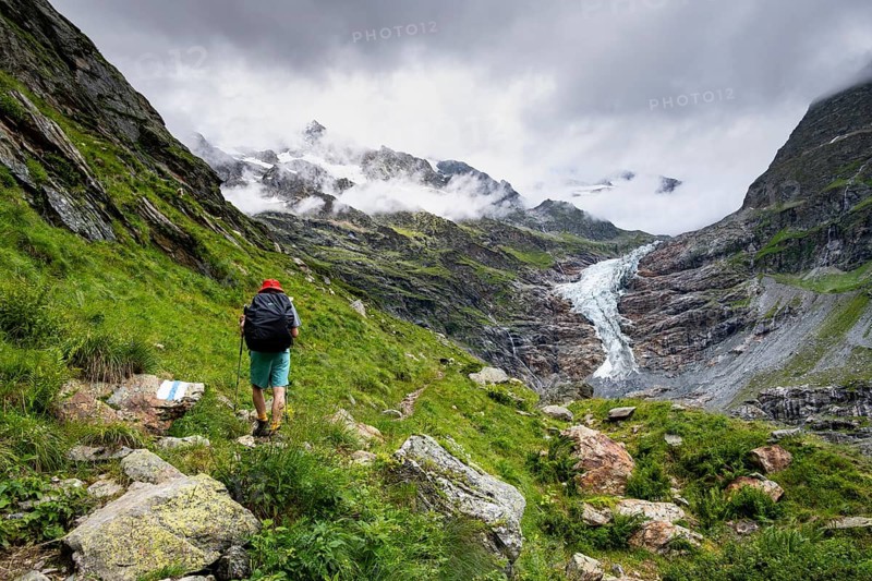 Mountaineers on a hiking trail, cloudy mountain landscape with Lower Arctic Sea glacier, Bernese Alps, Bernese Oberland, Switzerland
