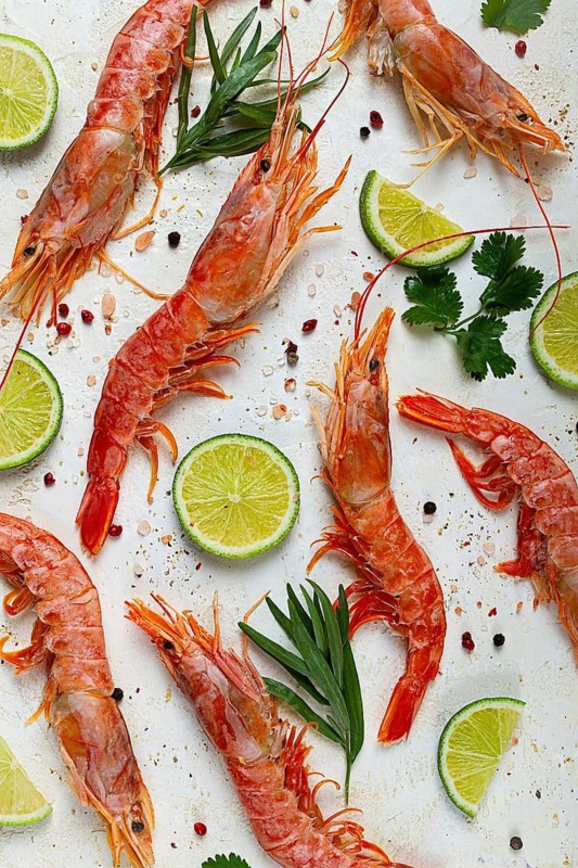 Langoustines, Australian, freshly frozen, top view, on a light background, lime and greens