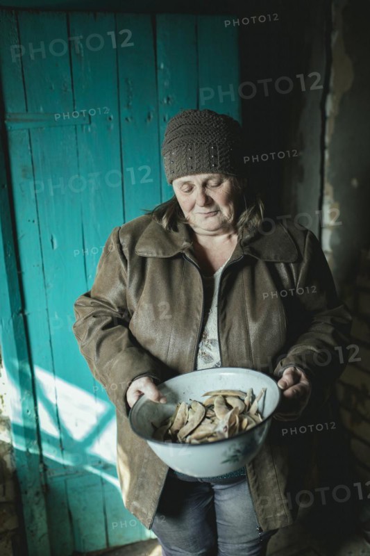 Larisa in her house in Borshchivka. The village was under Russian occupation. She hid in her house with her granddaughter Angelina for almost six months. The last beans from the last harvest for the new sowing season, without humanitarian aid she would not survive, Borshchivka, Raion Isyum, Kharkiv Oblast, Ukraine