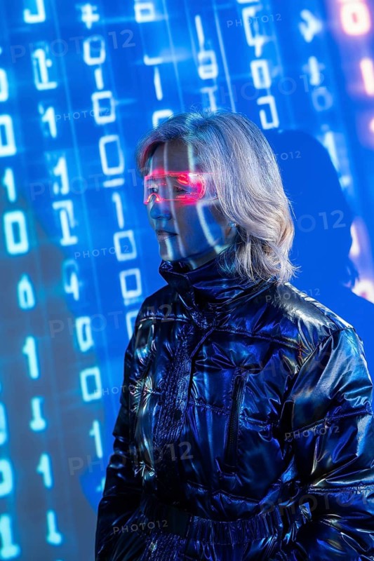 An elderly Asian woman wearing virtual reality glasses, exploring the dynamic and immersive world of the metaverse. The digital environment is filled with binary code visuals