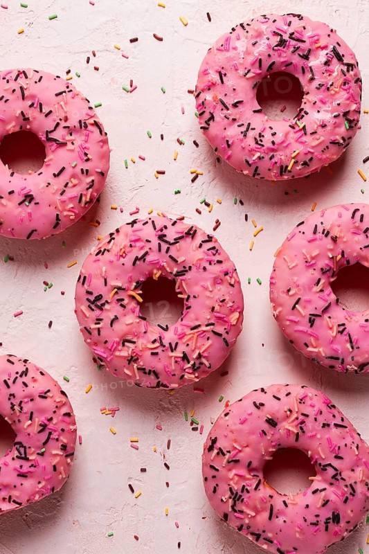 Donut with strawberries, in pink glaze, confectionery decoration, top view