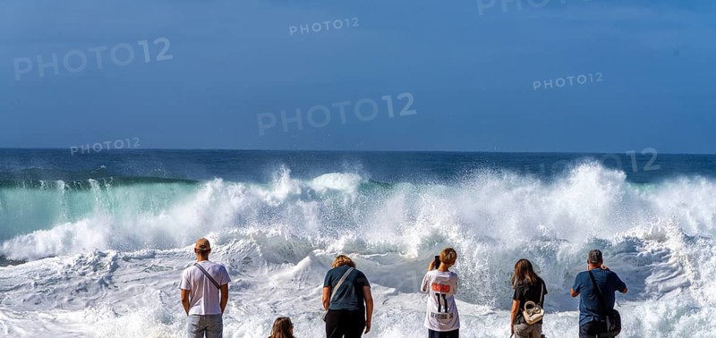Tourists watch the waves of the Atlantic on the rocky plateau of Sito, also known as Forte São Miguel, a surfing paradise with monster waves in the months of November to February, Nazaré, Portugal