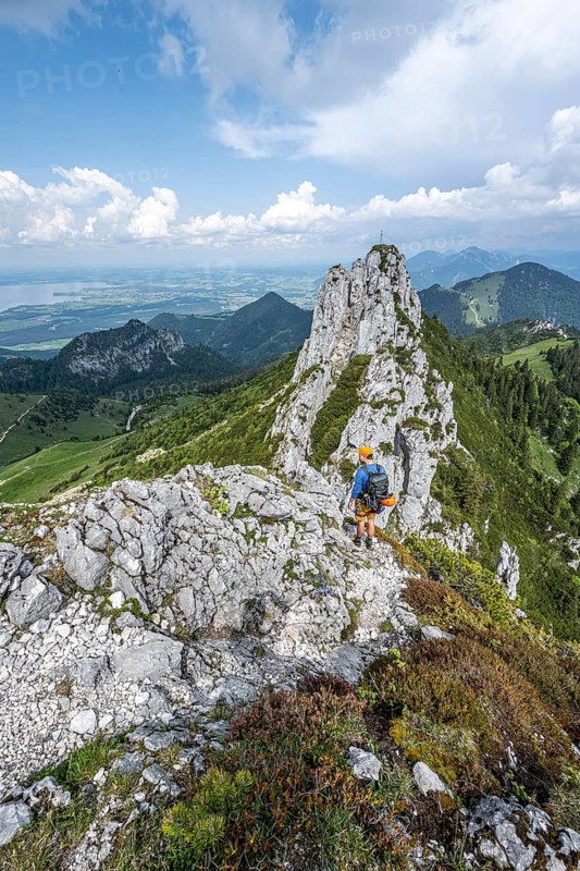 Climber on a climbing tour, on a mountain ridge, behind the summit of the Kampenwand with summit cross, alpine climbing, crossing the Kampenwand, Chiemgau, Bavaria, Germany