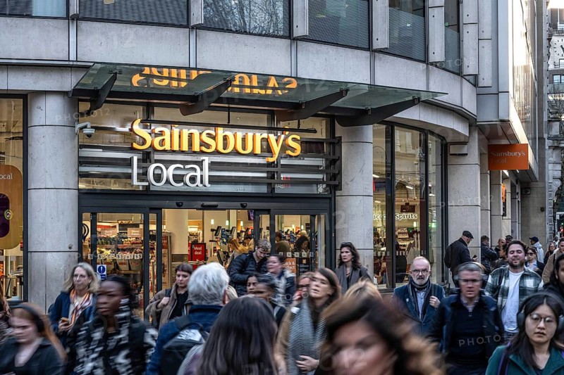 London, UK. February 25th 2026. A crowded busy street outside a Sainsbury Local retail supermarket in a central London shopping district. United Kingdom