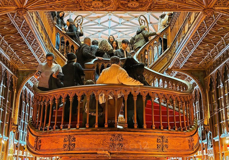 Livraria Lello, interior view of the Lello bookstore with lots of tourists on the curved wooden staircase, Overtourism, Porto, Portugal