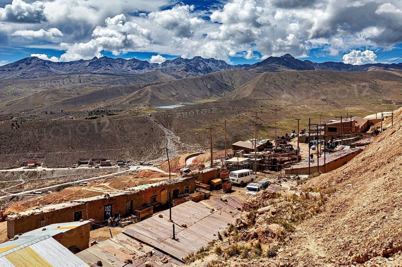 Wide mountain landscape with cloudy sky and small huts in the foreground, The silver mines of Potosi on Cerro Rico in Bolivia