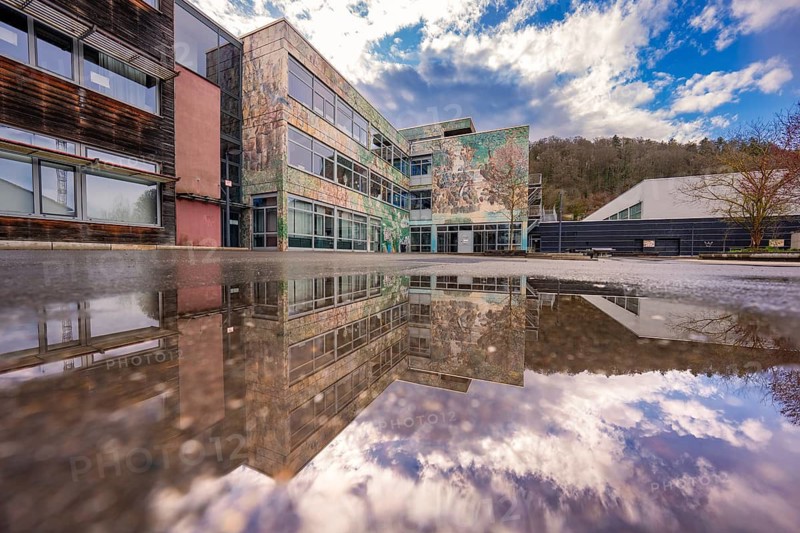 Modern building reflected in a water surface under a dramatic sky, Nagold, Calw district, Germany