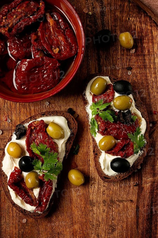 Sandwich with cream cheese, dried tomatoes, olives, breakfast, top view
