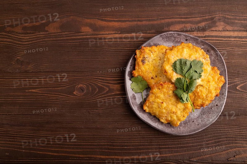 Fried crispy Chicken pancakes on brown wooden background. top view, flat lay, copy space