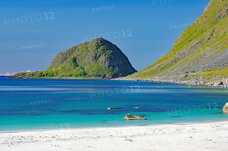 A secluded beach borders a crystal clear sea against a mountain backdrop, Haukland, Leknes, Vestvågøya, Lofoten, Nordland, Norway