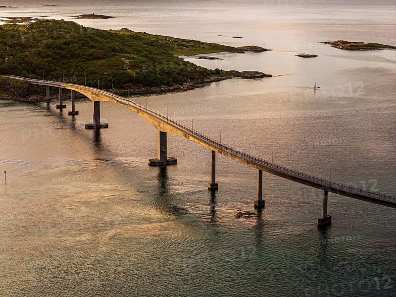 Sommaroy Bridge connecting Kvaloya Island to Sommaroy Island, warm light at sunset, aerial view, Norway