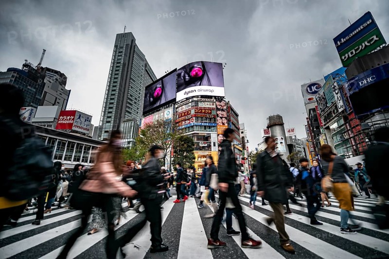 Crowd crossing zebra crossing on a large intersection, motion blur, back modern houses with colorful neon signs, long exposure, Shibuya Crossing, Shibuya, Tokyo, Japan