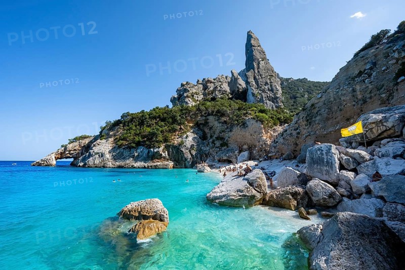 Light blue clear sea on a dream beach on Cala Goloritzé, picturesque rocky coast, steep coast with rock pin L'Aguglia, Golfo di Orosei, Baunei, Sardinia, Italy