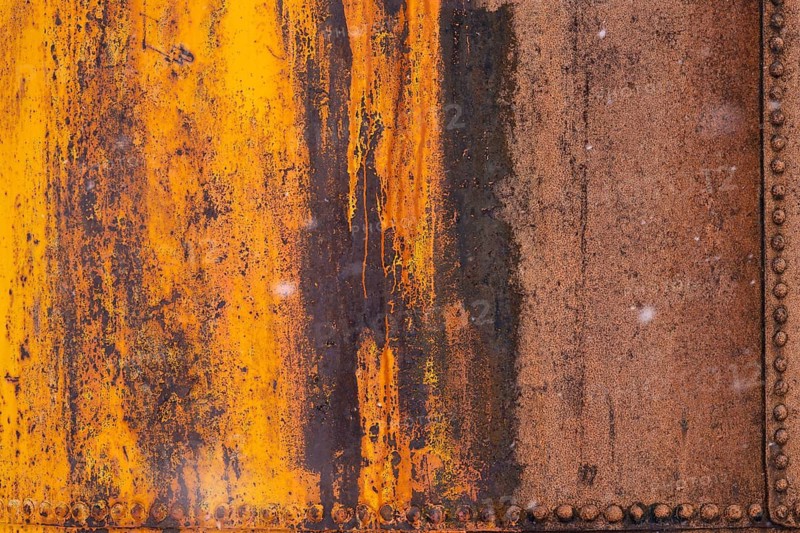 Rusted steel wall with peeling orange paint and rows of rivets, detailed view of an industrial plant, former Grytviken whaling station, South Georgia