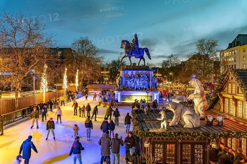 Christmas market Heinzel's winter fairy tale with the ice rink at Heumarkt and the equestrian monument to King Frederick William III of Prussia at dusk, Cologne, North Rhine-Westphalia, Germany