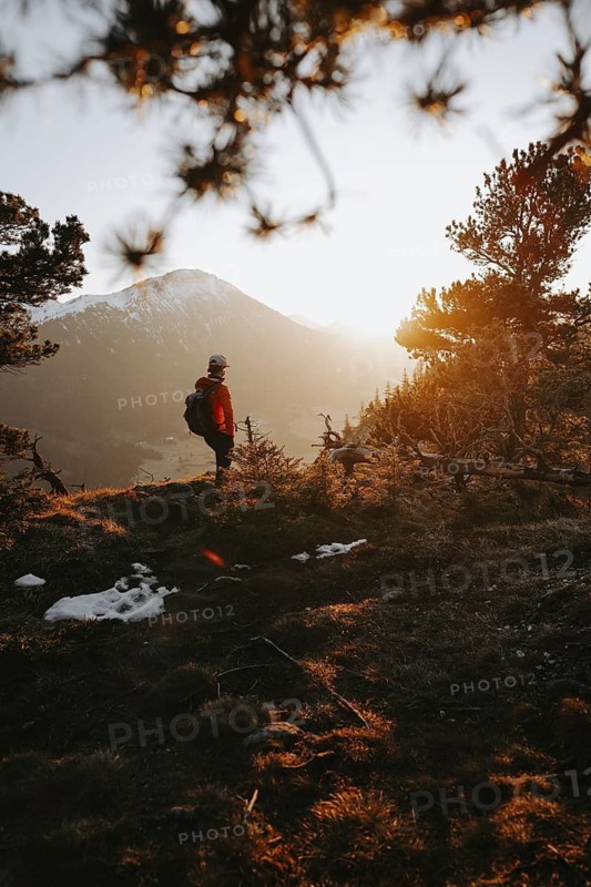 Hiker in the Allgäu at sunset in spring on the Zirmgrat near Pronten in the Allgäu