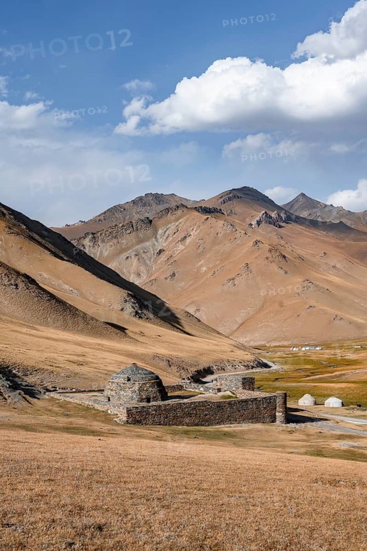 Historic caravanserai Tash Rabat from the 15th century, with yellow hills, Atbashy district in the Naryn region, Kyrgyzstan