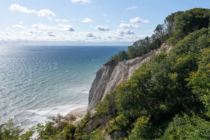 White chalk cliffs towering over the milky Baltic Sea with a view reaching the island of Rugen in Germany on the horizon. Møns Klint, Sjælland, Denmark