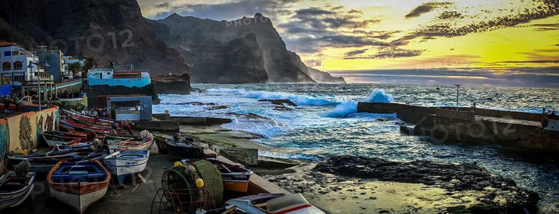 Sunset over a coastal landscape with colorful fishing boats and mountains, romantic harbor scene in dramatic evening light, Ponta do Sol, Santo Antao, Cabo Verde, Cape Verde, Cape Verde