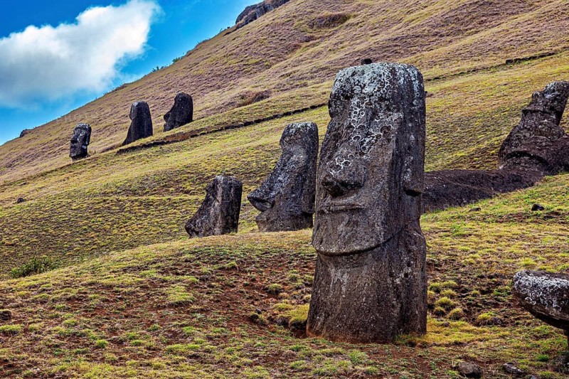 Several Moai statues on a grassy hill under cloudy skies on Easter Island, The Moai statues on Easter Island in the Pacific Ocean