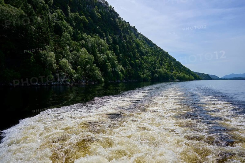 Water flow due to powerboat waves in a river lined with green hills, Fort Augustus, Loch Ness, Scotland, United Kingdom, Great Britain