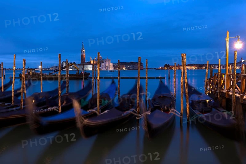 Nighttime atmosphere with moving gondolas, San Georgio Maggiore in the back, Guidecca Island on the right, Venice, Italy