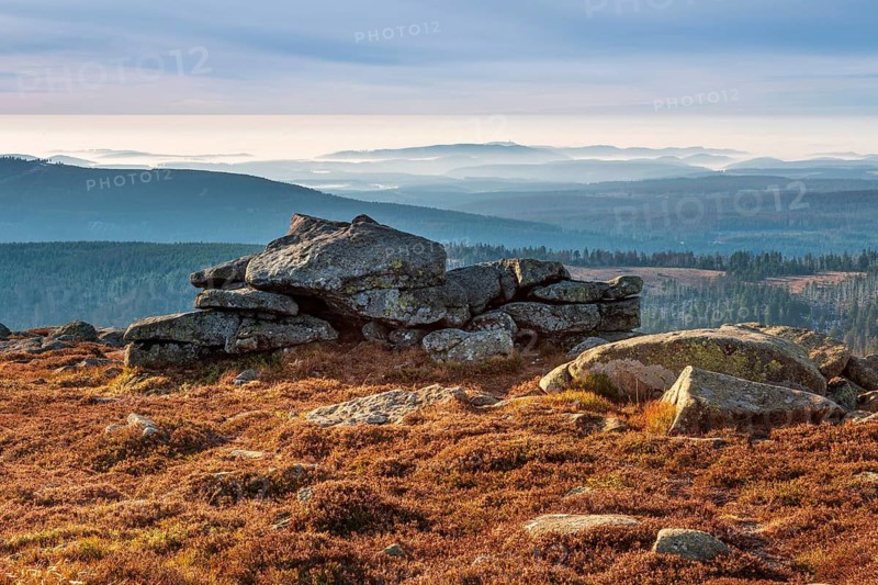 View from the summit of the Brocken to the south over the hills and forests of the Harz with morning fog, in front the Hexenaltar rock formation in the morning light, Harz National Park, Schierke, Saxony-Anhalt, Germany