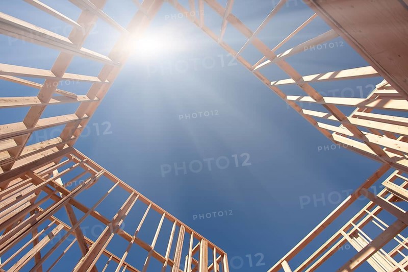 New Construction Framing Abstract with Sunburst Over Clear Blue Sky